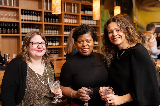 Three women with glass in hnad