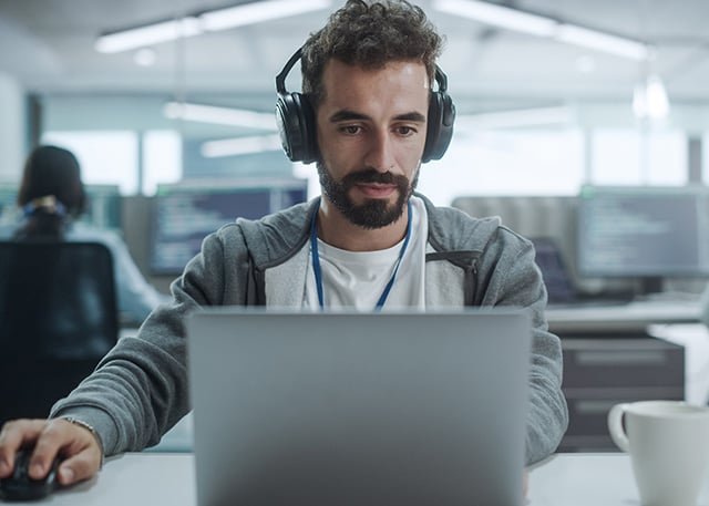 Man with headphones working on laptop